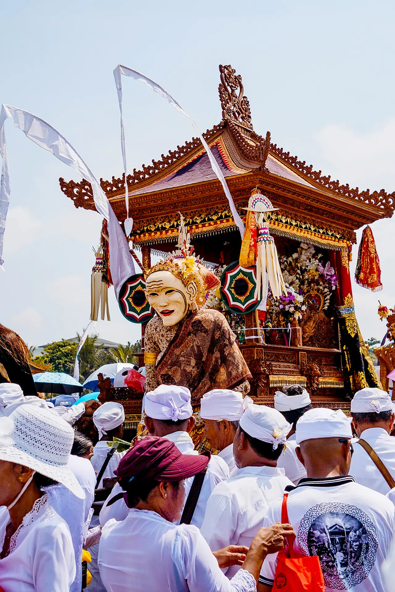 Community members in traditional dress gathered before a Balinese temple.